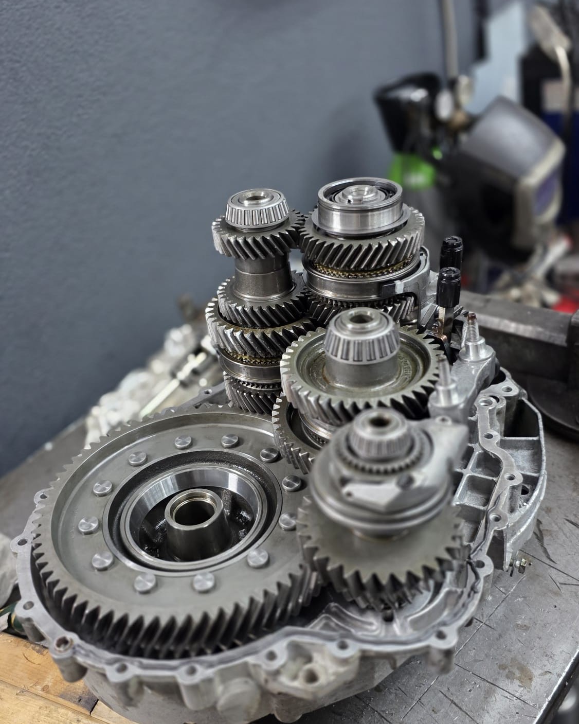 Een uit elkaar gehaalde versnellingsbak op de werkbank bij Ponchi Garage